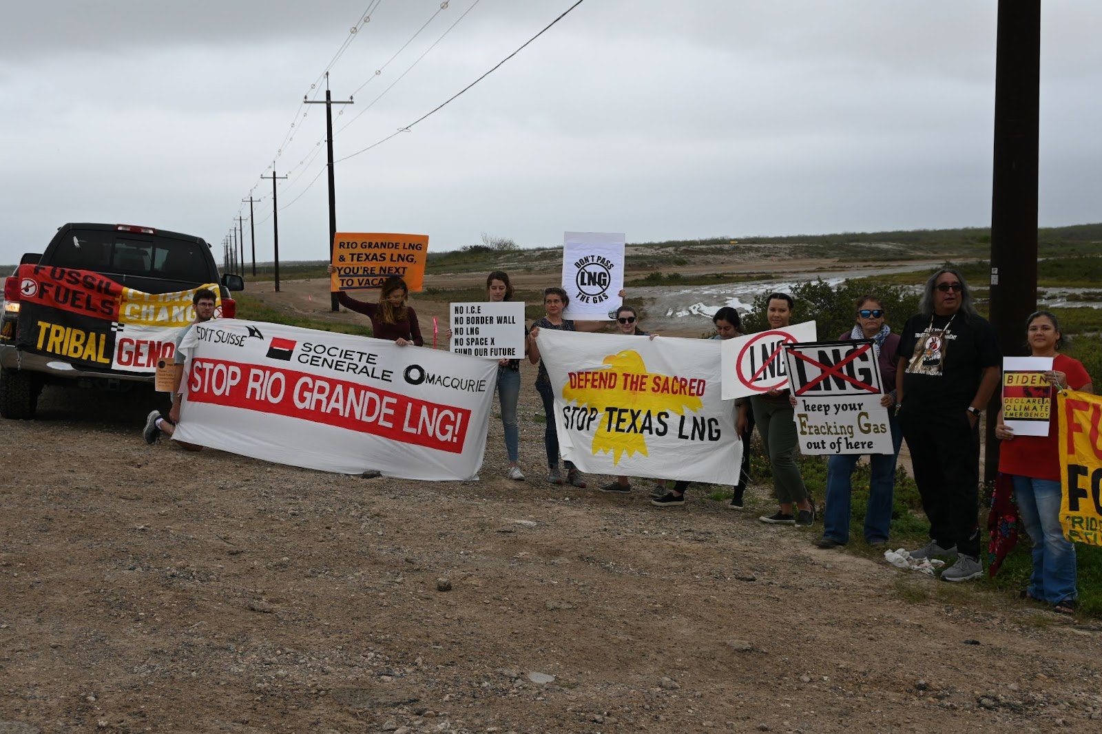 A photo of people on the side of the road holding signs a part of a rally against Rio Grande LNG
