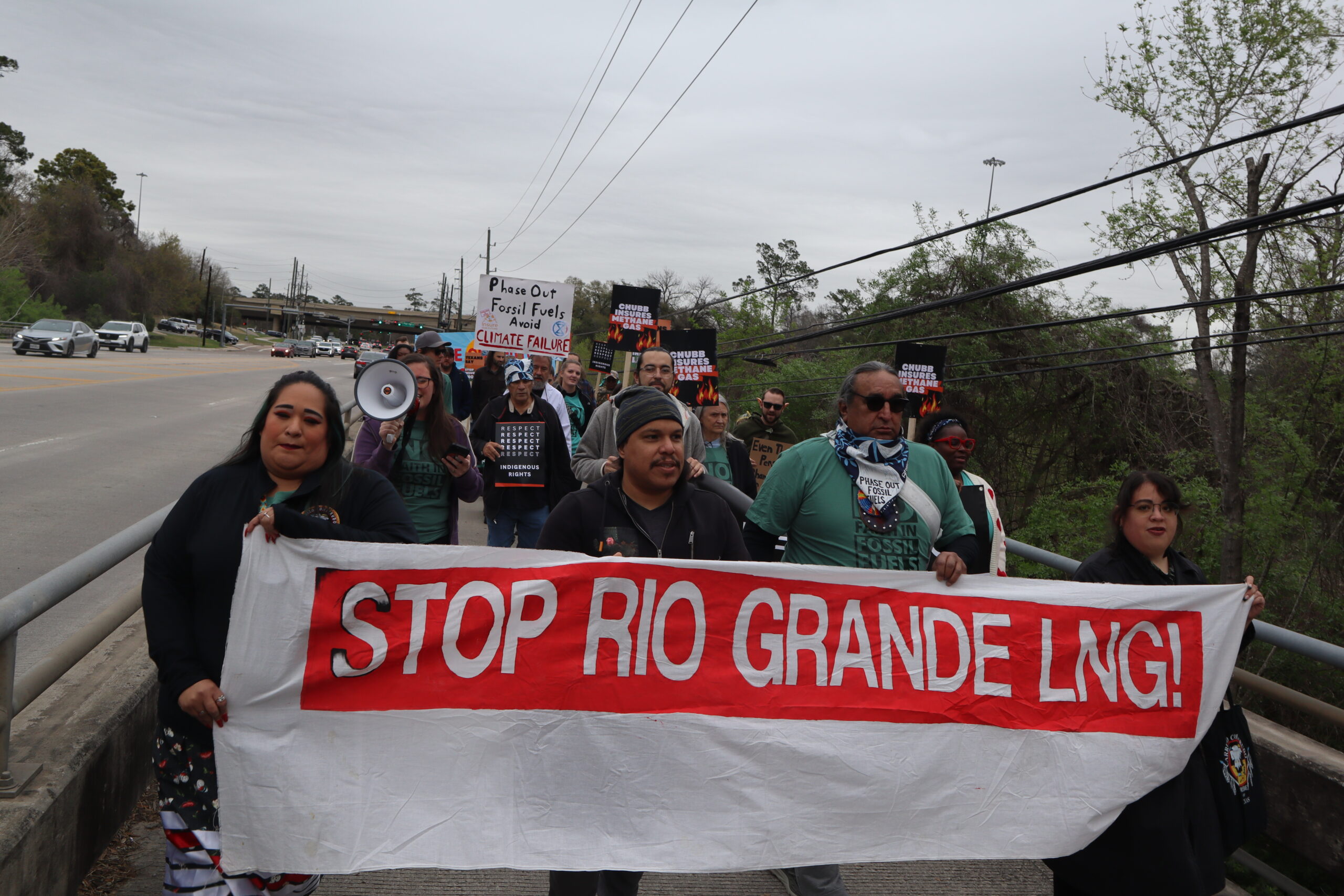 A picture of a group of protesters holding a large banner that reads Stop Rio Grande LNG!